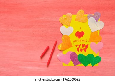 Child Made Card For Grandma. Colorful Pink Background With Paper Decoration, Multicolored Hearts,  Handmade Concept For Birthday, Mothers Day And Grandparents Day
