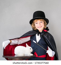 Child Magician With Cute Rabbit. Happy Kid Playing At Home. Imagination And Magic Trick Concept