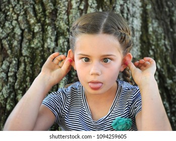 Child Makes An Aweful Face Because It Is Monday Again And It Is Back To School For Her.  Her Tongue Is Stuck Out, Eyes Are Crossed And Her Ears Flapped Forward.