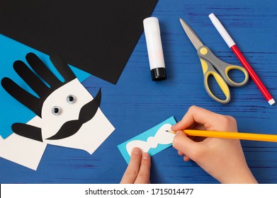 Child makes card for Father's Day. Children's craft during quarantine. How to captivate children at home during COVID-19 coronavirus pandemic. Step-by-step photos. Step 10. Draw bow tie - Powered by Shutterstock