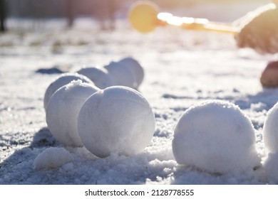 A child makes snowballs out of snow using a snowball toy. Winter frosty sunny day in nature. Winter children's outdoor games.