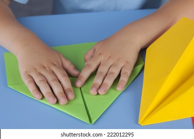 Child Making A Paper Plane.