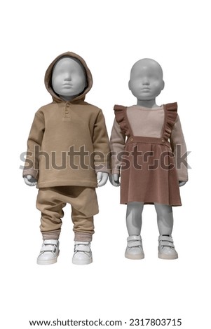 Child mannequins dressed in beige clothes isolated on white background with clipping path. No brand names or copyright objects. Boy and girl in stylish clothes