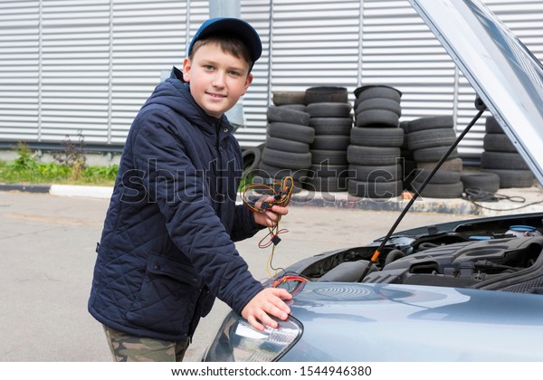 Child\
mechanic working in the garage. Repair\
service.