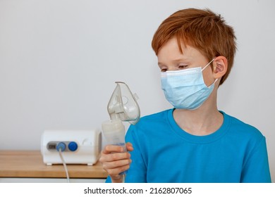 A Child In A Medical Mask Holds A Nebulizer In His Hands. Cough Treatment Concept, Covid19