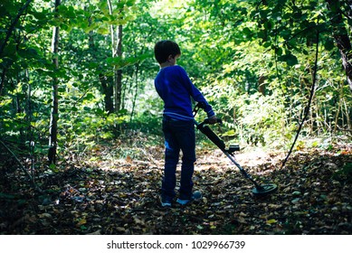 Child With Metal Detector In The Woods In Spring