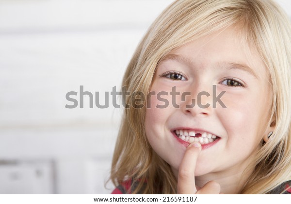 Child
missing front tooth pointing at it with her
finger