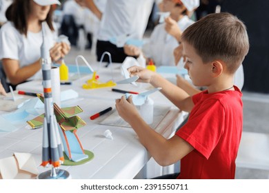 Child models a mock-up of an airplane. A preschooler is engaged in creativity. Children's creativity - Powered by Shutterstock