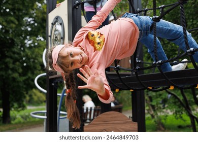 Child, monkey bars and energy on playground, smiling and obstacle course on outdoor adventure at park. Happy girl, active and exercise on jungle gym, fitness on vacation or holiday - Powered by Shutterstock