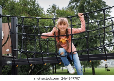 Child, monkey bars and energy on playground, smiling and obstacle course on outdoor adventure at park. Happy girl, active and exercise on jungle gym, fitness on vacation or holiday