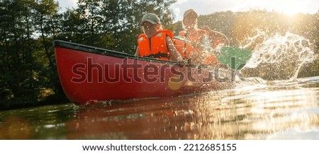 Child with mother and father in a  Canoe on river. Summer camp for kids. Kayaking and canoeing with family. Children on canoe. Family on kayak ride. Wild nature and water fun on summer vacation.