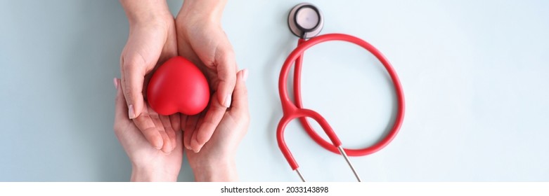 Child And Mother Holding Red Toy Heart On Background Of Stethoscope Closeup