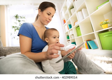 Child And Mother Pointing And Using Tablet Close Up