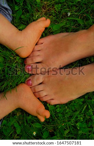 child and mother's feet in grass