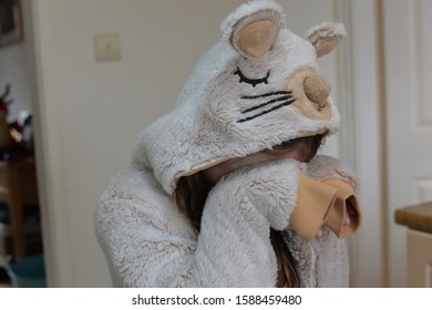 A Child In A Mouse Animal Onesie Covering Their Face And Pretending To Cry Or Be Upset