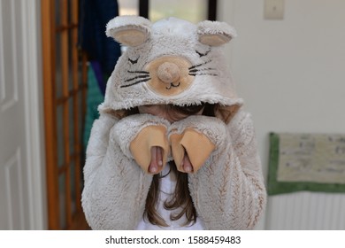 A Child In A Mouse Animal Onesie Covering Their Face And Pretending To Cry Or Be Upset