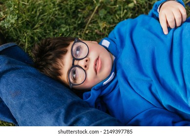 Child With Multiple Disabilities Enjoying The Outdoors While Laying On The Grass In The Park.