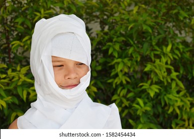 Child In Mummy Costume. Boy Wrapped Himself In Toilet Paper. Little Boy Is Playing Mummy.  Toilet White Paper On The Head. Funny Boy Plays In Fresh Air. The Boy In Toilet Paper.