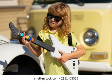 Child Musician Playing The Guitar Like A Rockstar Outdoor. Kid Boy Rock Musician With Guitar. Kid With Guitar.