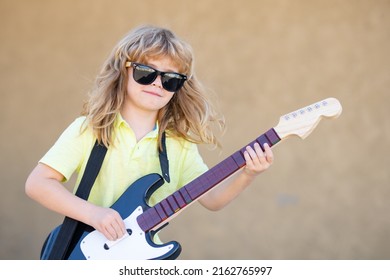 Child Musician Playing The Guitar Like A Rockstar Outdoor. Kid Boy Rock Musician With Guitar. Music Kids.