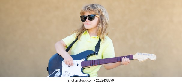 Child Musician Playing The Guitar Like A Rockstar Outdoor. Kid Boy Rock Musician With Guitar. Kids Musical Instruments, Banner.