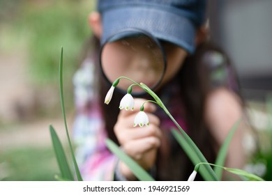 A Child Observing Lily Of The Valley With A Magnifying Glass