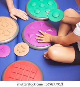 Child With Occupational Therapist Touching Sensory Integration Equipment