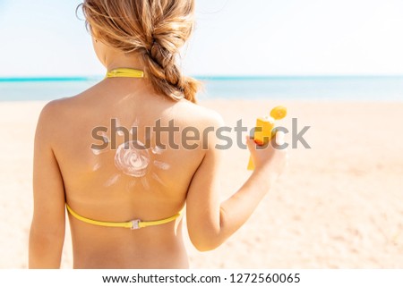 child on the beach smears sunscreen. Selective focus. People.