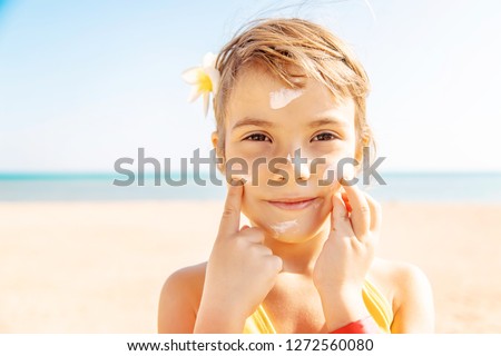 child on the beach smears sunscreen. Selective focus. People.