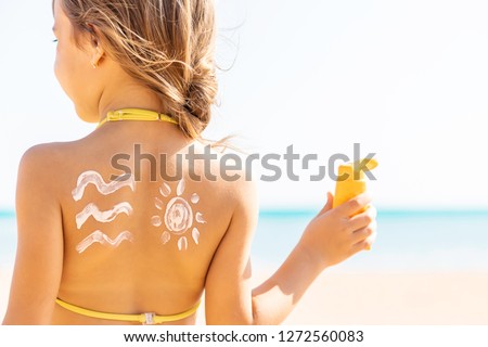 child on the beach smears sunscreen. Selective focus. People.