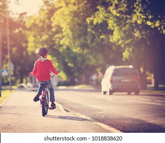 Child On A Bicycle At Asphalt Road In Summer. Bike In The Park. Boy Cycling Outdoors On Beautiful Sunny Evening