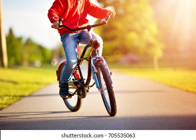 Child On A Bicycle At Asphalt Road In Early Morning