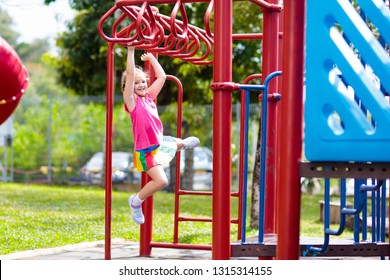 Child on monkey bars. Kid at school playground. Little girl hanging on gym activity center of preschool play ground. Healthy outdoor activity for kids. Sport for young children. - Powered by Shutterstock