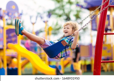 Child on swing playing on outdoor playground. Kids play on school or kindergarten yard. Active kid swinging. Healthy summer activity for children. Little boy having fun outdoors. - Shutterstock ID 1648931950