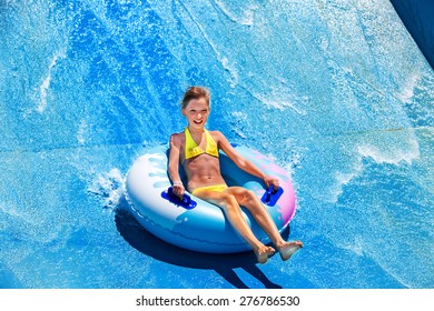 Child On Water Slide At Aquapark. Summer Holiday.