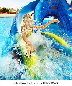 Child On Water Slide At Aquapark. Summer Holiday.