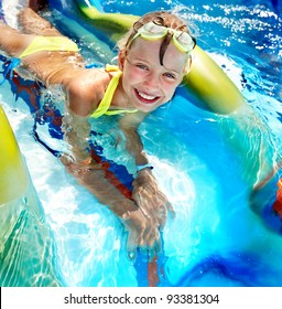 Child on water slide at aquapark. Summer holiday.