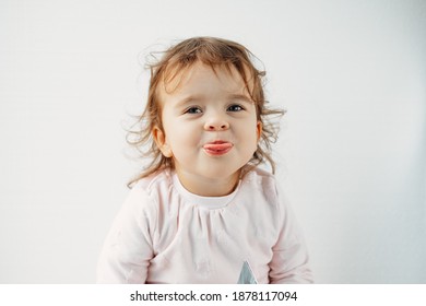 A Child On A White Background Shows His Tongue In His Mouth, Emotions.