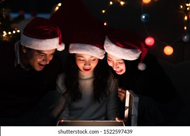 Child Open Christmas Gift. Mixed Race Family, White Man, Asian Woman, Young Girl Opening Magical Gift Box Together. Lovely Family.