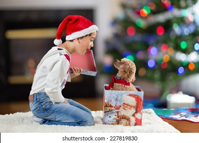 A Child Opening A Christmas Gift Box With A Puppy Inside