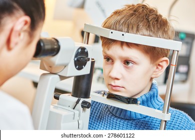 Child Optometry. Female Optometrist Optician Doctor Examines Eyesight Of Little Boy Patient In Eye Ophthalmological Clinic 