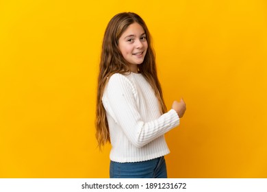 Child Over Isolated Yellow Background Pointing Back