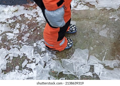 A Child In Overalls Walks On Thin Ice 