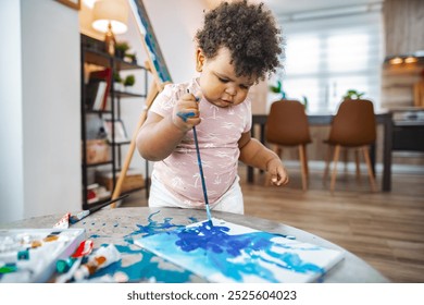 Child painting bright colors at home in the afternoon - Powered by Shutterstock