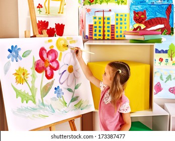 Child painting at easel in art class. - Powered by Shutterstock