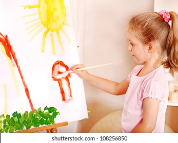 Child Painting At Easel In School. Education.