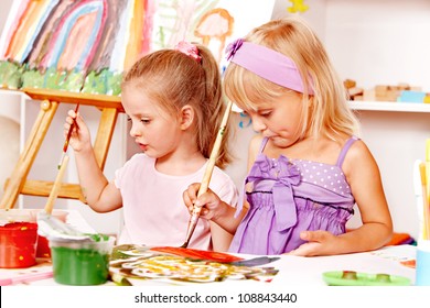 Child Painting At Easel In School. Education.