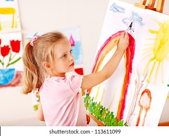 Child Painting At Easel In School. Education.