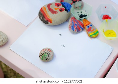 Child Painting Pebbles With Brush