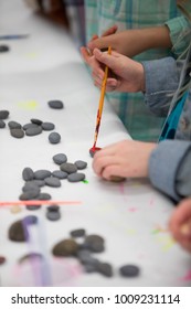 Child Painting Rocks In Class